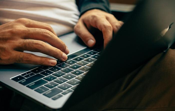 Händer som skriver på ett tangentbord på laptop